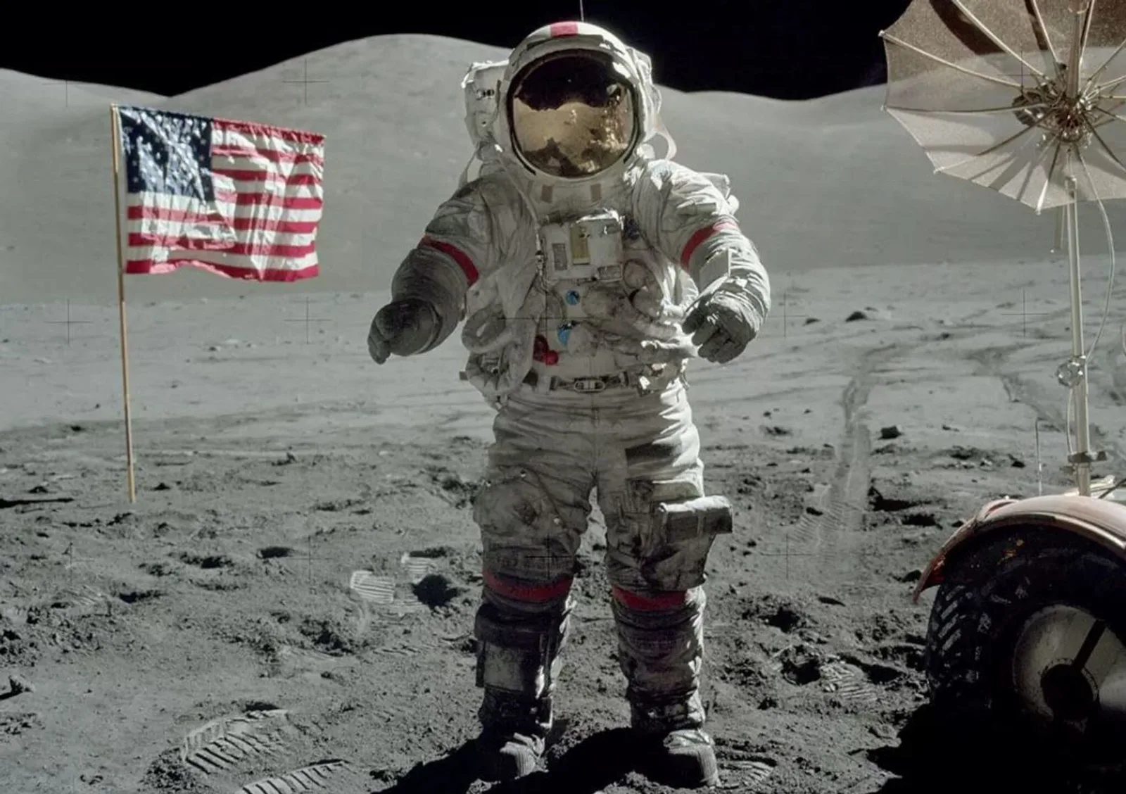 Astronautas del Apolo 17 caminando sobre la superficie lunar polvorienta con la Tierra al fondo